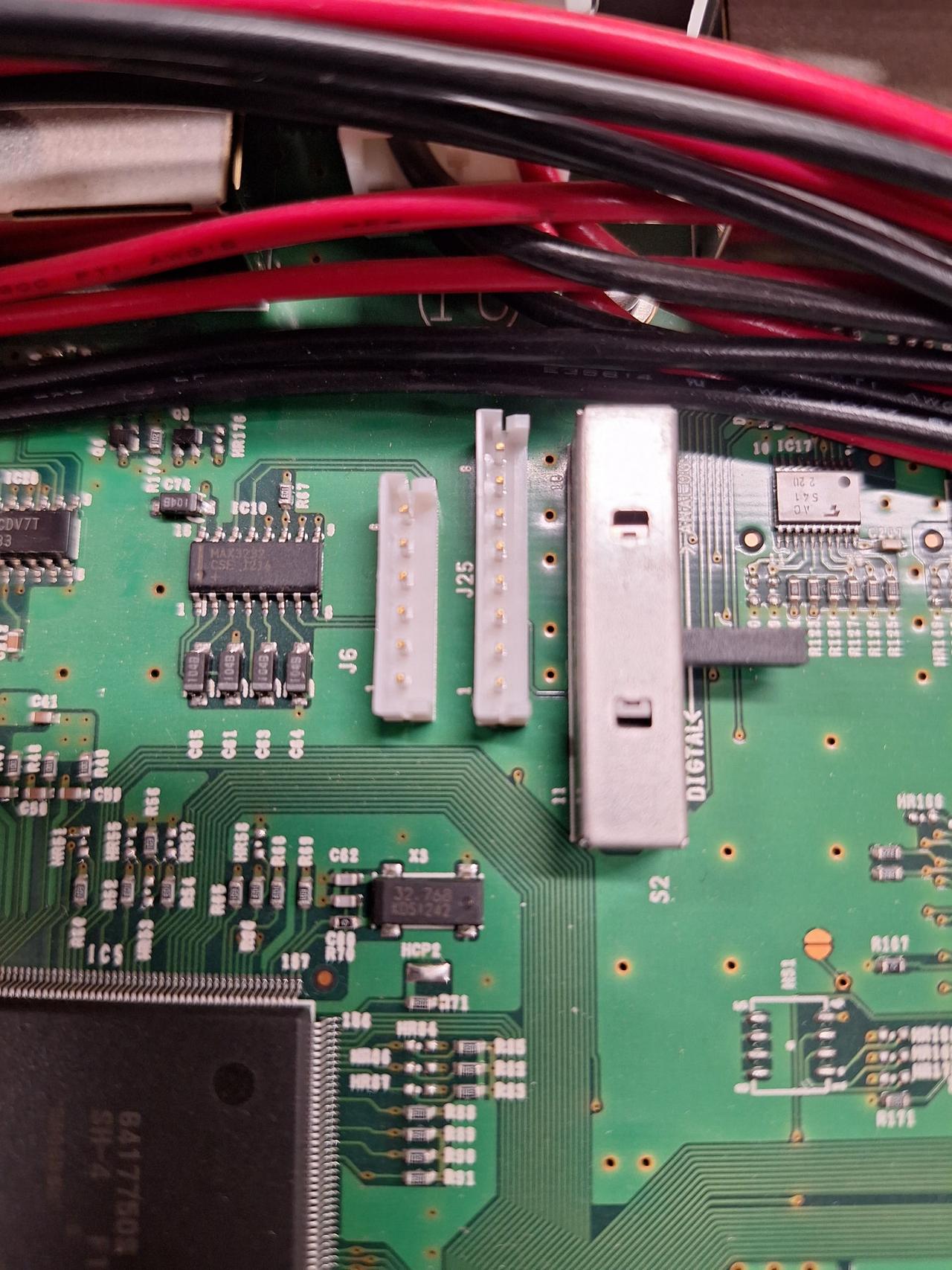 Close-up of the ID-RP2C controller PCB showing two small white JST-style headers labelled 'J6' (left) and 'J25' (right). Pin 1 of each is marked with a '1' at the bottom of the connector. A MAX3232 RS-232 level shifter chip is visible to the left of J6, and the Hitachi SH-4 processor sits at the bottom of the frame.